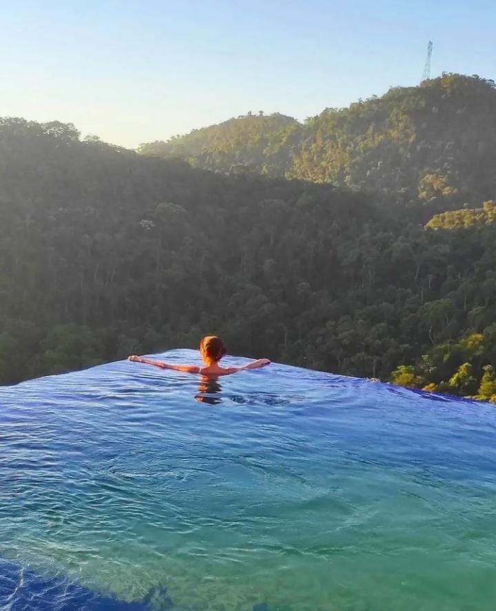 This image depicts a minimalist arrangement of ceramic teaware, including a teapot, sugar bowl, creamer, and teacup on a l...
